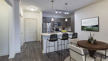 The Hendrix Apartments an open kitchen and dining area with a table and chairs at The Hendrix, Georgia, 30329